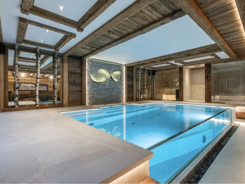 The indoor pool at Chalet Infinity, running the length of a room panelled in old timber