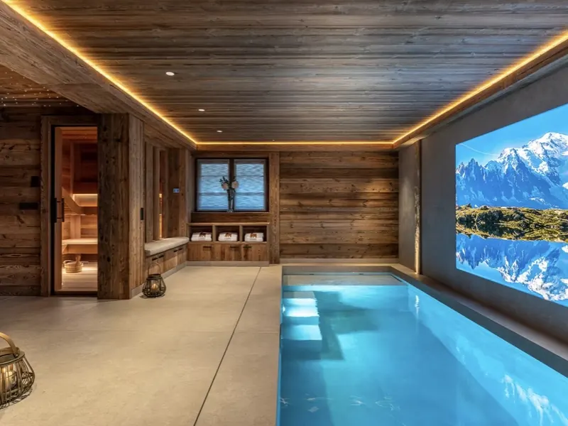 The pool and sauna at Chalet L'Orri, lit warm against dark timber walls