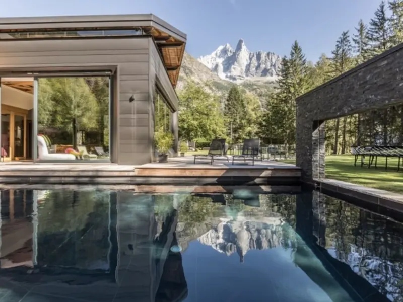 The heated outdoor pool at Chalet Dalmore, the Aiguilles reflected in still water, Les Praz