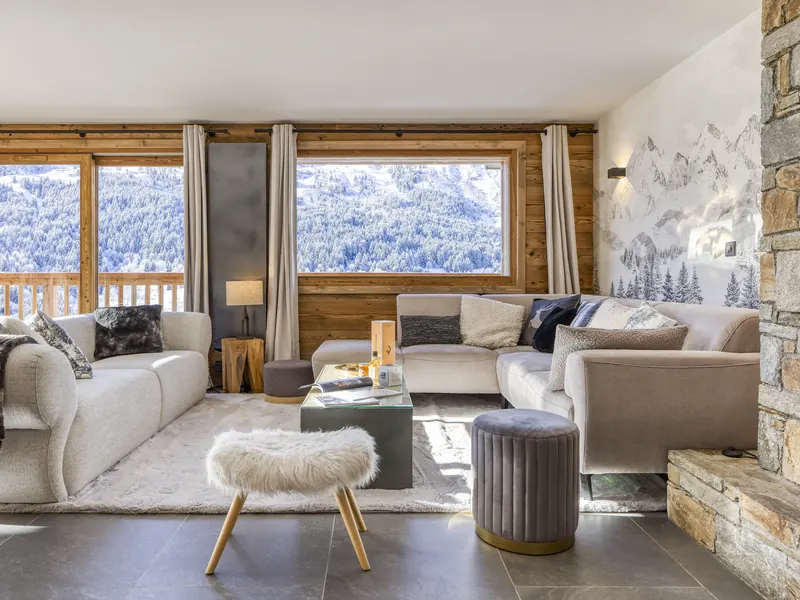 The living room at Chalet Alpine Roc, wide windows onto the snow-covered Méribel valley