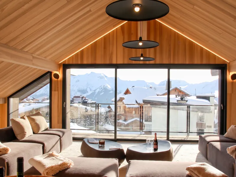 The living room of Apartment Hemera, opening onto a terrace above the rooftops of L'Alpe d'Huez