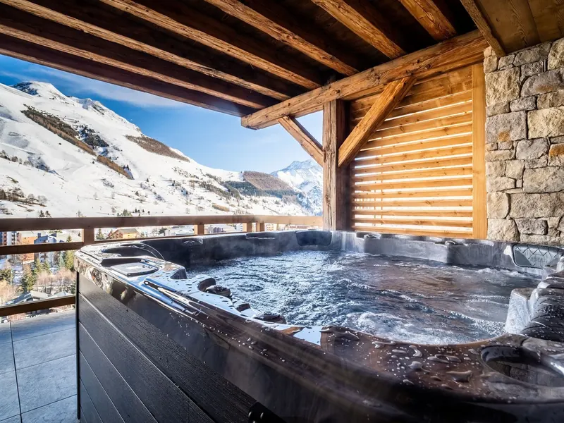 The hot tub at Chalet Meije, steaming under a beamed roof above the snowfields of Les 2 Alpes