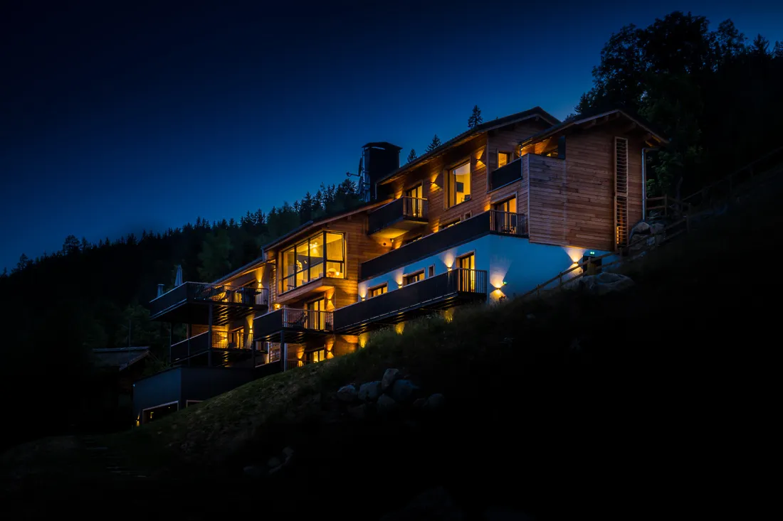 The chalet at night, its windows lit against the snow