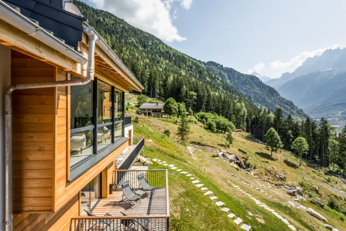 The chalet at dusk, warm windows and the garden path